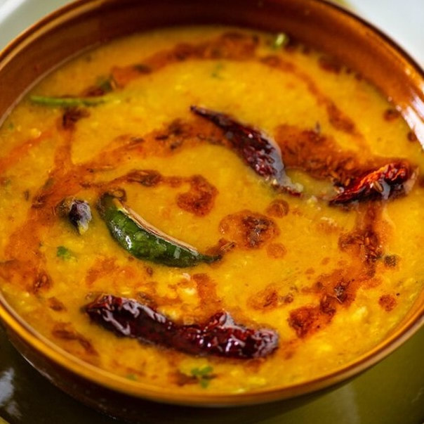 A swirled creamy lentil dal soup with flavoured oils spiralled on top